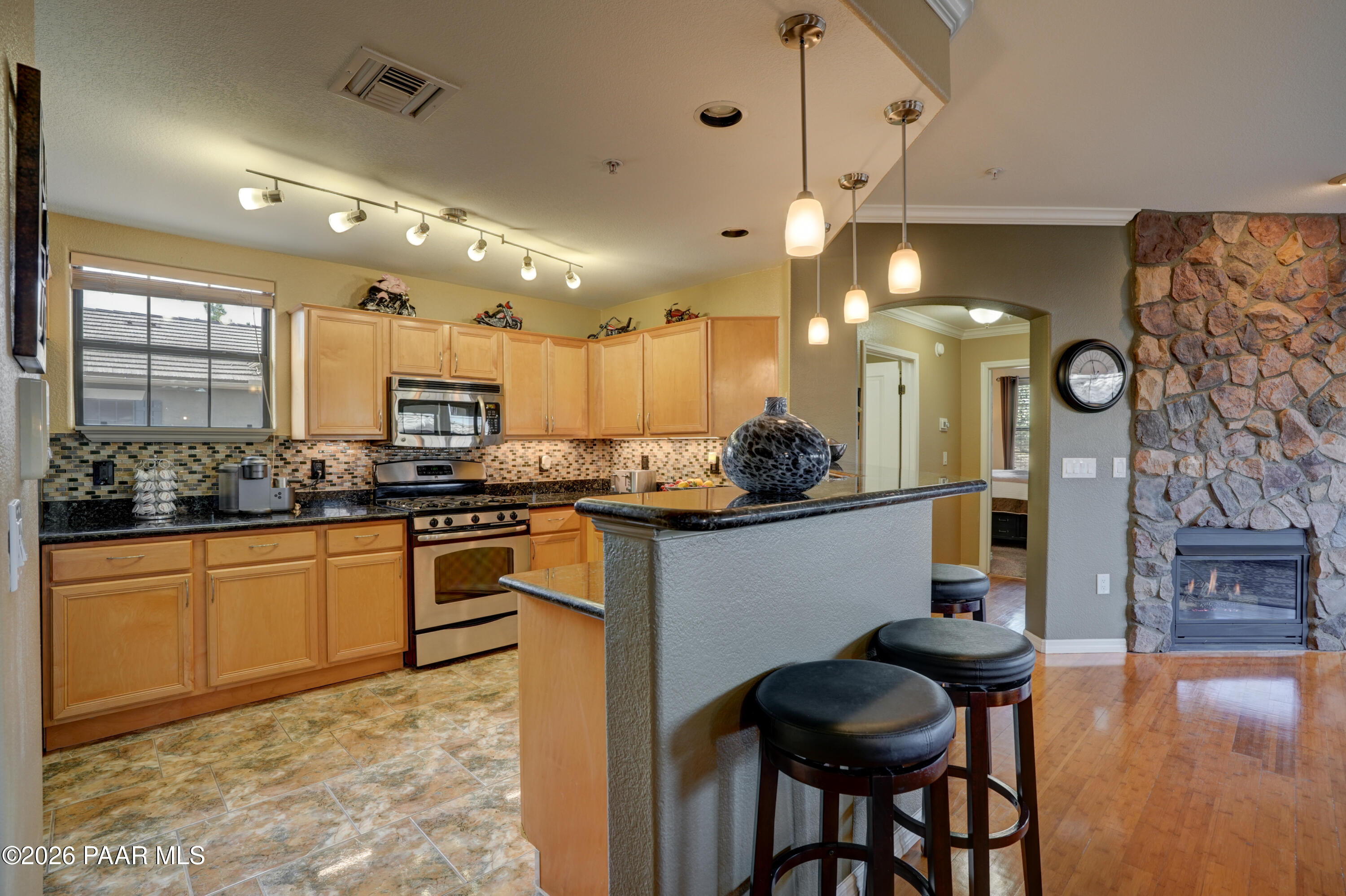 1716 Alpine Meadows Lane, Unit 405 Prescott, AZ 86303 - Photo 13 of 29 a kitchen with stainless steel appliances kitchen island granite countertop a sink and cabinets