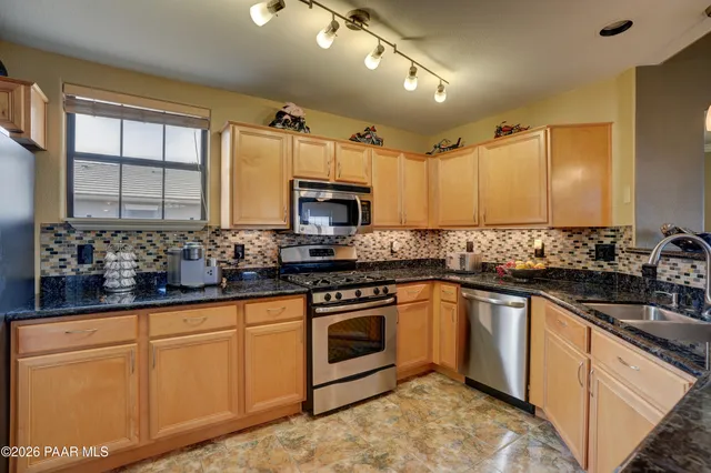 a kitchen with sink a microwave and cabinets