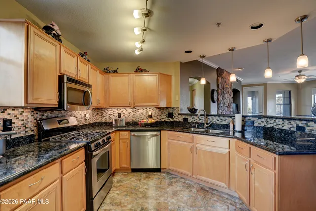 a kitchen with stainless steel appliances a sink stove and cabinets