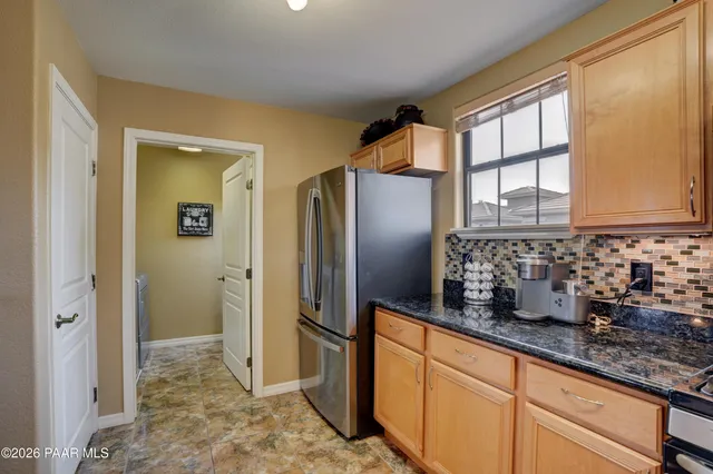 a kitchen with stainless steel appliances granite countertop a refrigerator and a sink