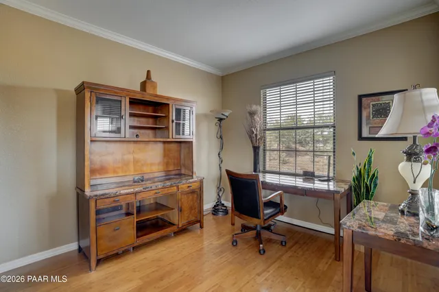 a view of a workspace with furniture and a window
