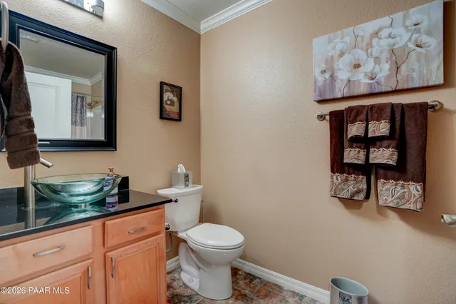 a bathroom with a toilet a sink and painting on the wall