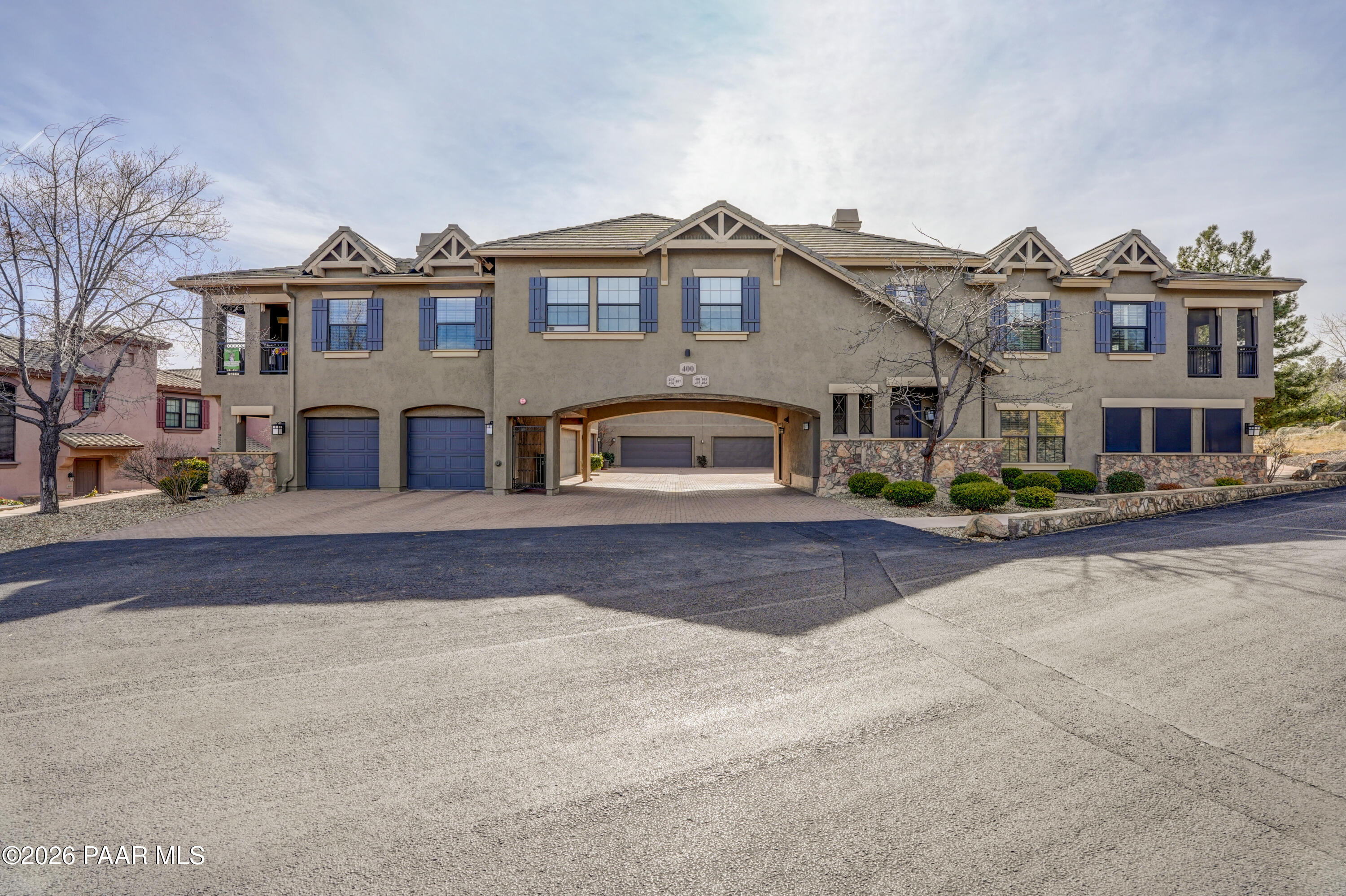 1716 Alpine Meadows Lane, Unit 405 Prescott, AZ 86303 - Photo 4 of 29 a front view of a house with a yard and a garage