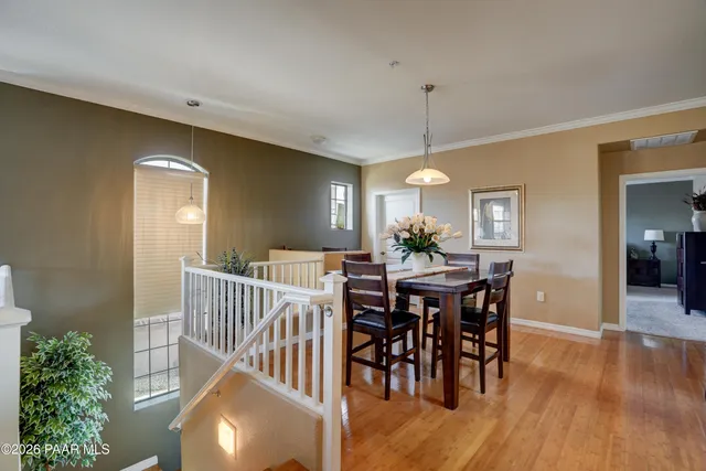a view of a a dining room with furniture window and wooden floor