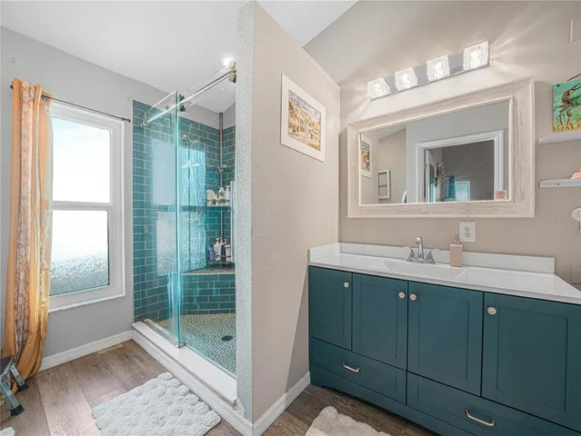 a bathroom with a shower sink and mirror