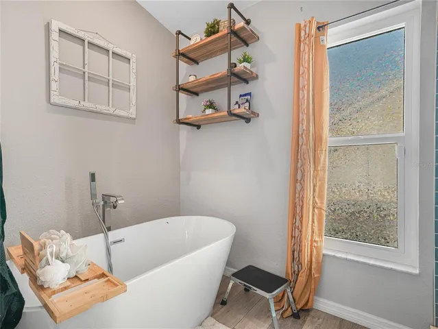 a bathroom with a tub and a window
