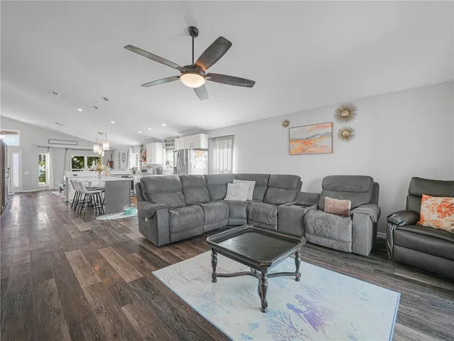 a living room with furniture a ceiling fan and a rug