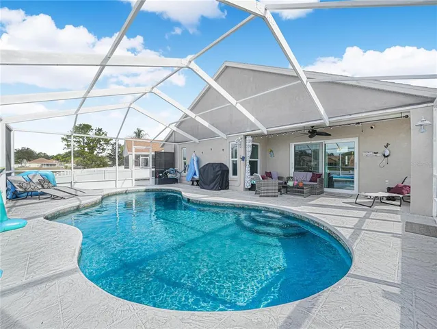 a swimming pool with outdoor seating and yard