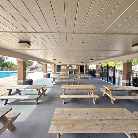 a living room with furniture pool table and large windows
