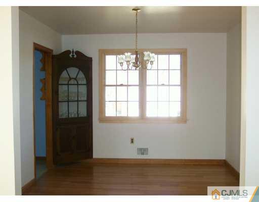 172 Normandy Road Colonia, NJ 07067 - Photo 3 of 5 a view of an empty room with wooden floor and a window