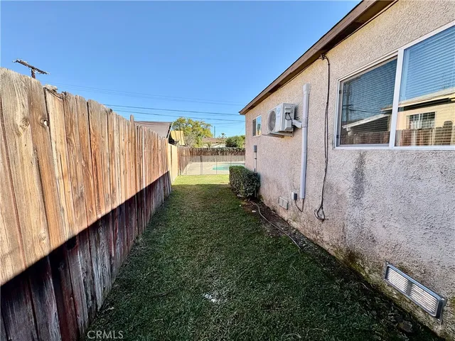 a view of a back yard with wooden fence