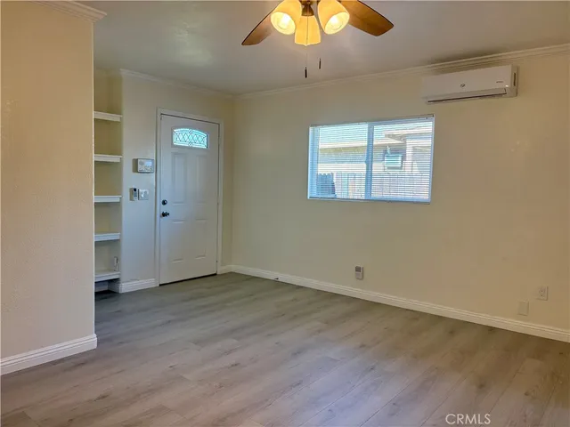 an empty room with wooden floor closet and chandelier fan