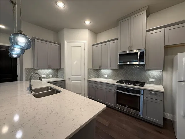 a kitchen with kitchen island granite countertop stainless steel appliances and wooden cabinets