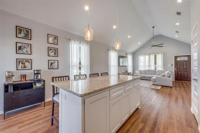 a kitchen with stainless steel appliances granite countertop a sink a stove and cabinets