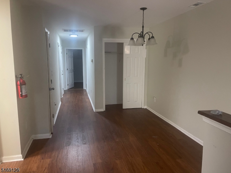 406 South 7th Street, Unit 2 Newark, NJ 07103 - Photo 5 of 9 a view of a hallway with wooden floor and a chandelier