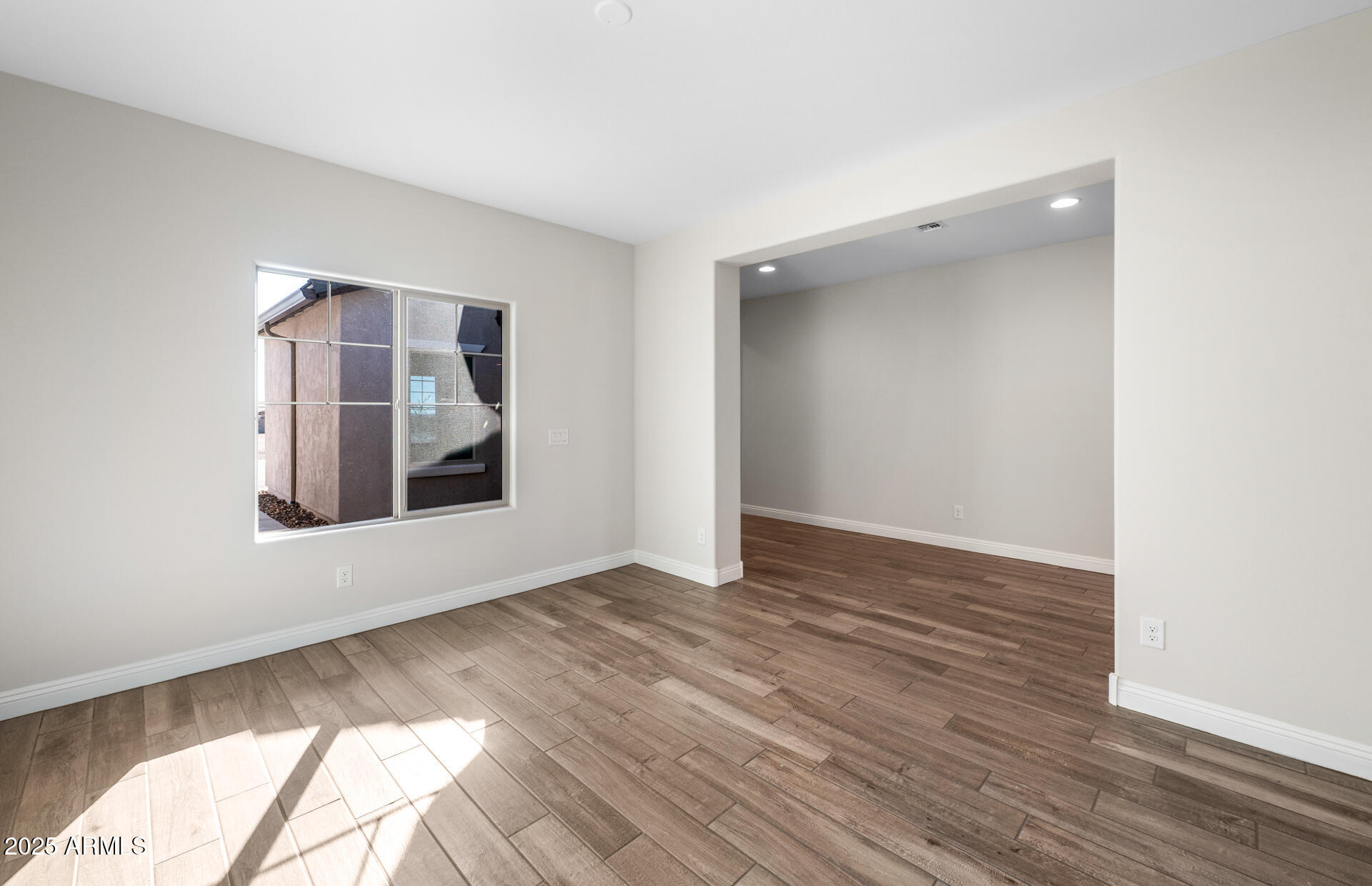6808 West Ripken Way Florence, AZ 85132 - Photo 16 of 38 a view of an empty room with wooden floor and a window