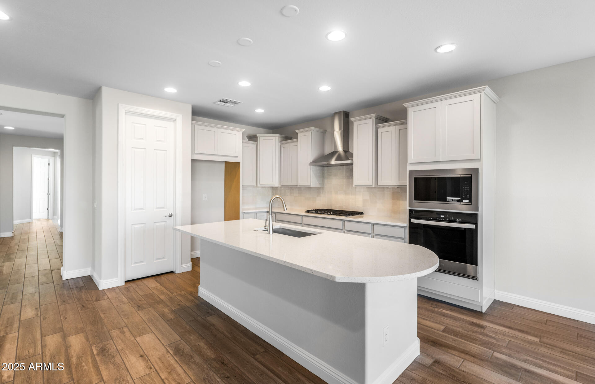 6808 West Ripken Way Florence, AZ 85132 - Photo 22 of 38 a kitchen with white cabinets and stainless steel appliances