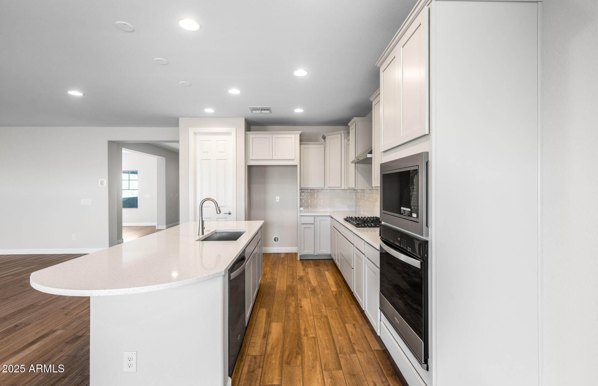 6808 West Ripken Way Florence, AZ 85132 - Photo 23 of 38 a kitchen with kitchen island a sink table and chairs