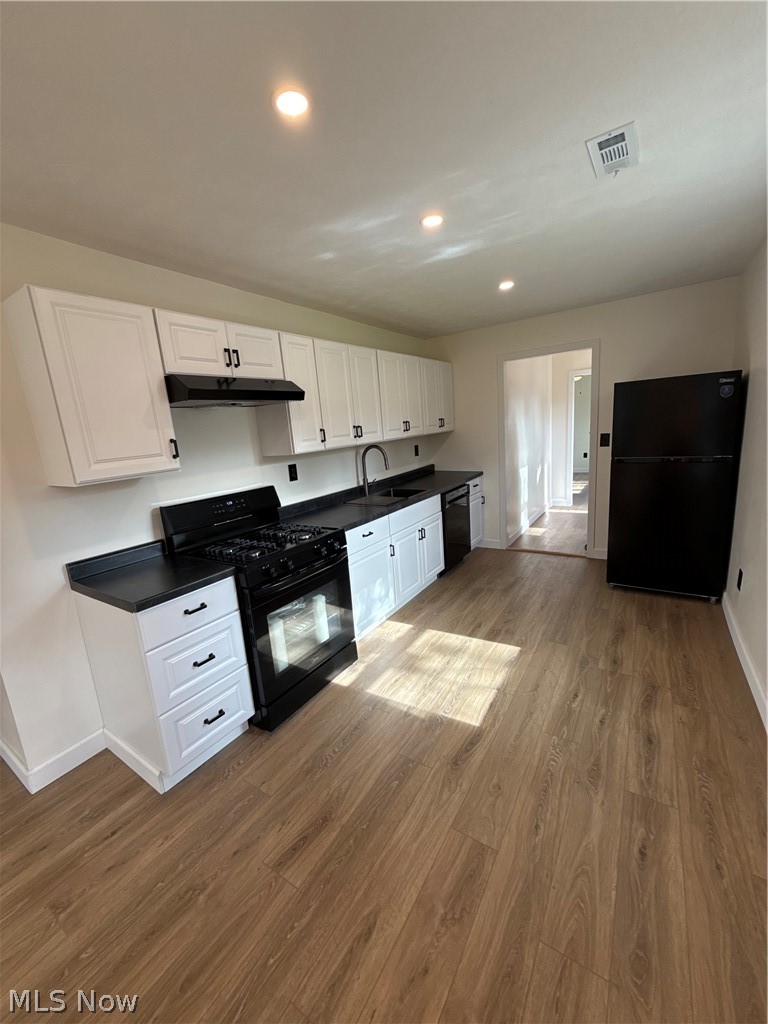 4841 Marigold Road Mentor, OH 44060 - Photo 3 of 12 Kitchen featuring white cabinetry with black hardware, black countertops, and a black gas range