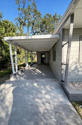 a view of an entrance to house with yard and outdoor seating