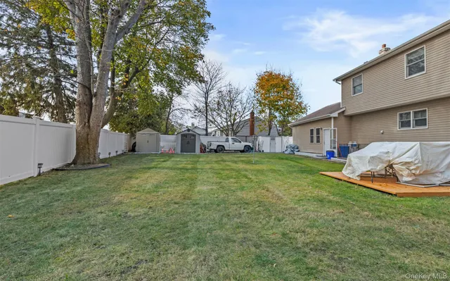 a view of a house with backyard and a tree