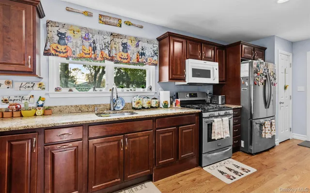 a kitchen with stainless steel appliances granite countertop a sink stove and refrigerator