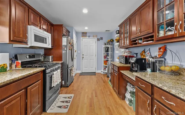 a large kitchen with stainless steel appliances granite countertop a stove a sink dishwasher and cabinets with wooden floor