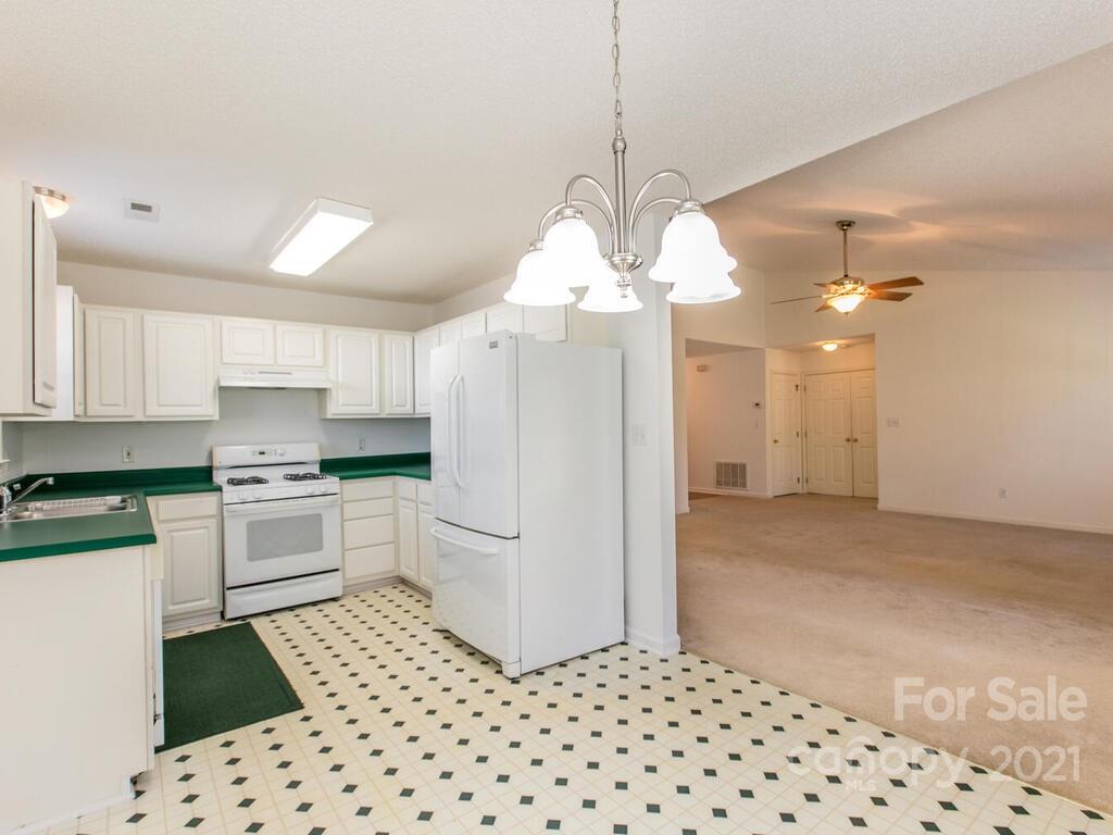 83 Planters Creek Road Fletcher, NC 28732 - Photo 15 of 38 a kitchen with a refrigerator a sink and cabinets