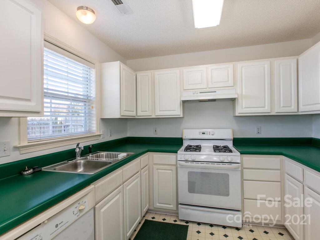 83 Planters Creek Road Fletcher, NC 28732 - Photo 16 of 38 a kitchen with granite countertop a sink a stove a microwave and cabinets