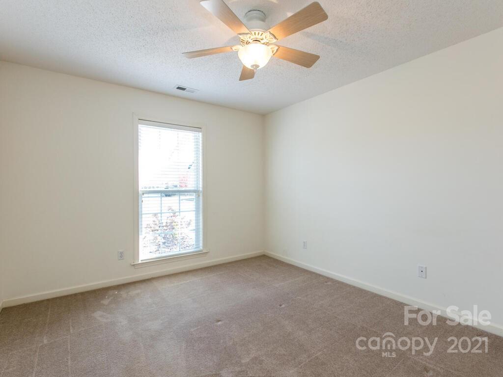 83 Planters Creek Road Fletcher, NC 28732 - Photo 24 of 38 an empty room with a window and a fan