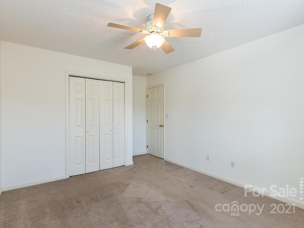 83 Planters Creek Road Fletcher, NC 28732 - Photo 26 of 38 an empty room with a chandelier fan