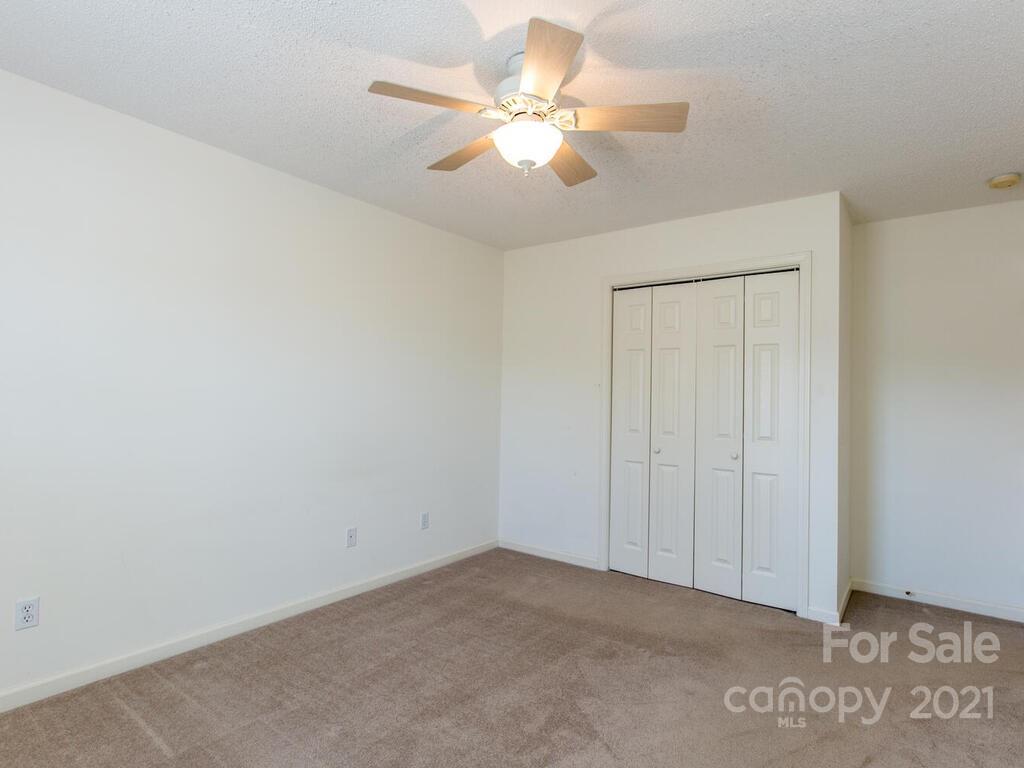 83 Planters Creek Road Fletcher, NC 28732 - Photo 27 of 38 an empty room with windows and fan
