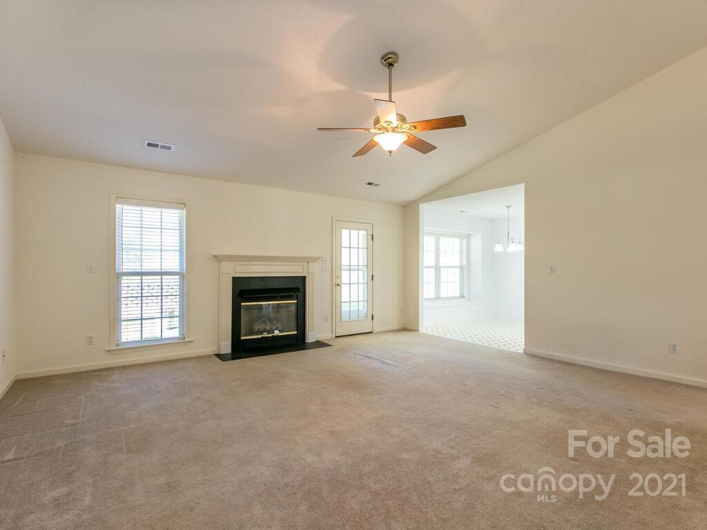 83 Planters Creek Road Fletcher, NC 28732 - Photo 8 of 38 a view of an empty room with a fireplace and a window