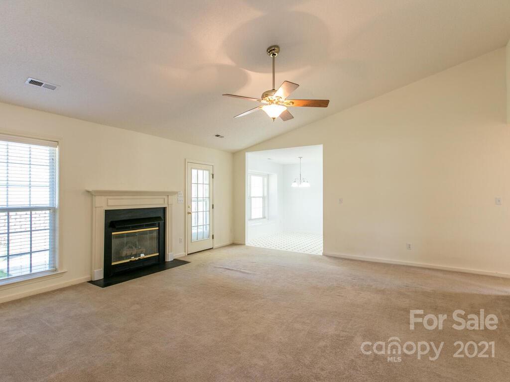 83 Planters Creek Road Fletcher, NC 28732 - Photo 9 of 38 an empty room with windows fireplace and a kitchen view