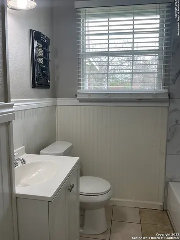 a bathroom with a toilet a sink and a window