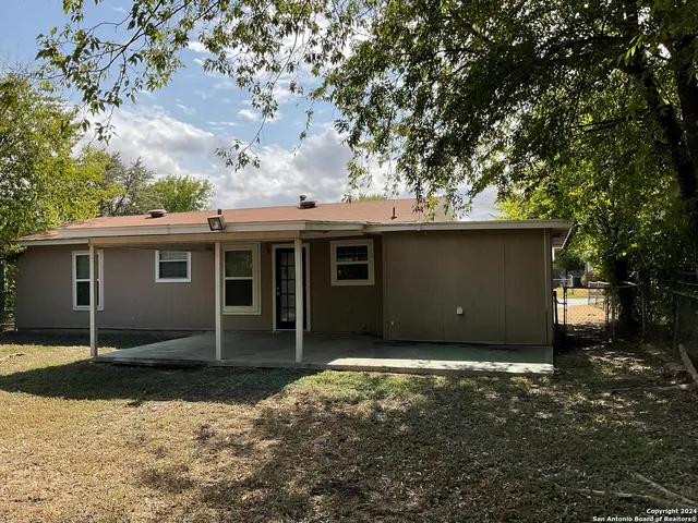 a front view of a house with a tree