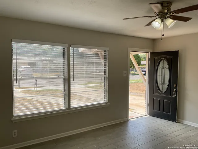 a view of a livingroom with furniture window and a ceiling fan