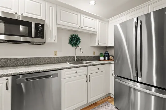 a kitchen with stainless steel appliances a refrigerator sink and microwave