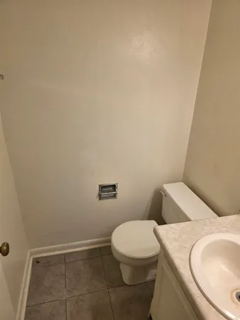 a white toilet sitting next to a white sink and vanity