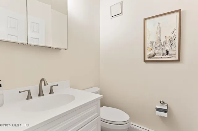 a bathroom with a toilet a sink and mirror