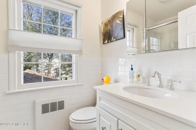 a bathroom with a sink a toilet and a window