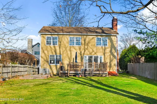 a view of a house with backyard and a tree
