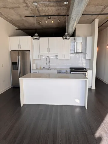 a view of kitchen with stainless steel appliances wooden floor