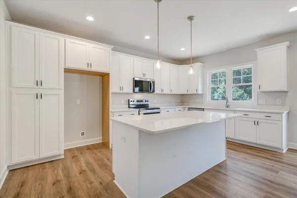 a kitchen with kitchen island a sink stainless steel appliances and cabinets