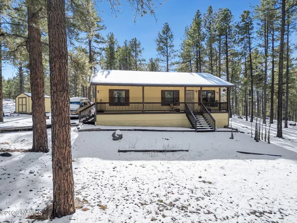 a view of a white house with a yard covered in snow