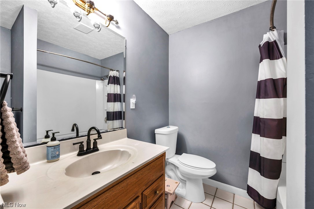 3324 Poe Road Medina, OH 44256 - Photo 20 of 26 Bathroom with large vanity, tile flooring, a textured ceiling, and toilet