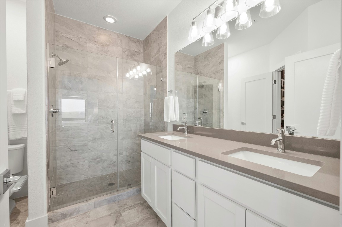 2050 Lohmans Spur Road, Unit 101 Lakeway, TX 78738 - Photo 18 of 31 a bathroom with a sink double vanity and shower
