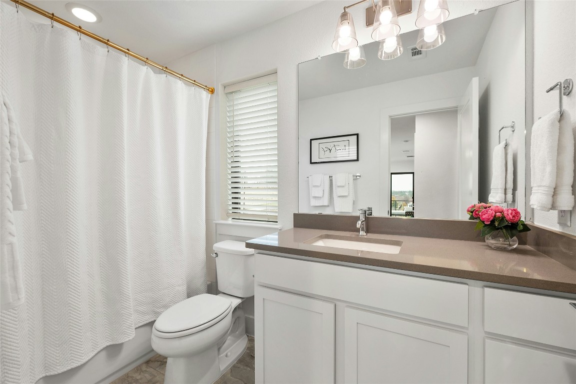 2050 Lohmans Spur Road, Unit 101 Lakeway, TX 78738 - Photo 20 of 31 a bathroom with a sink a toilet and a mirror