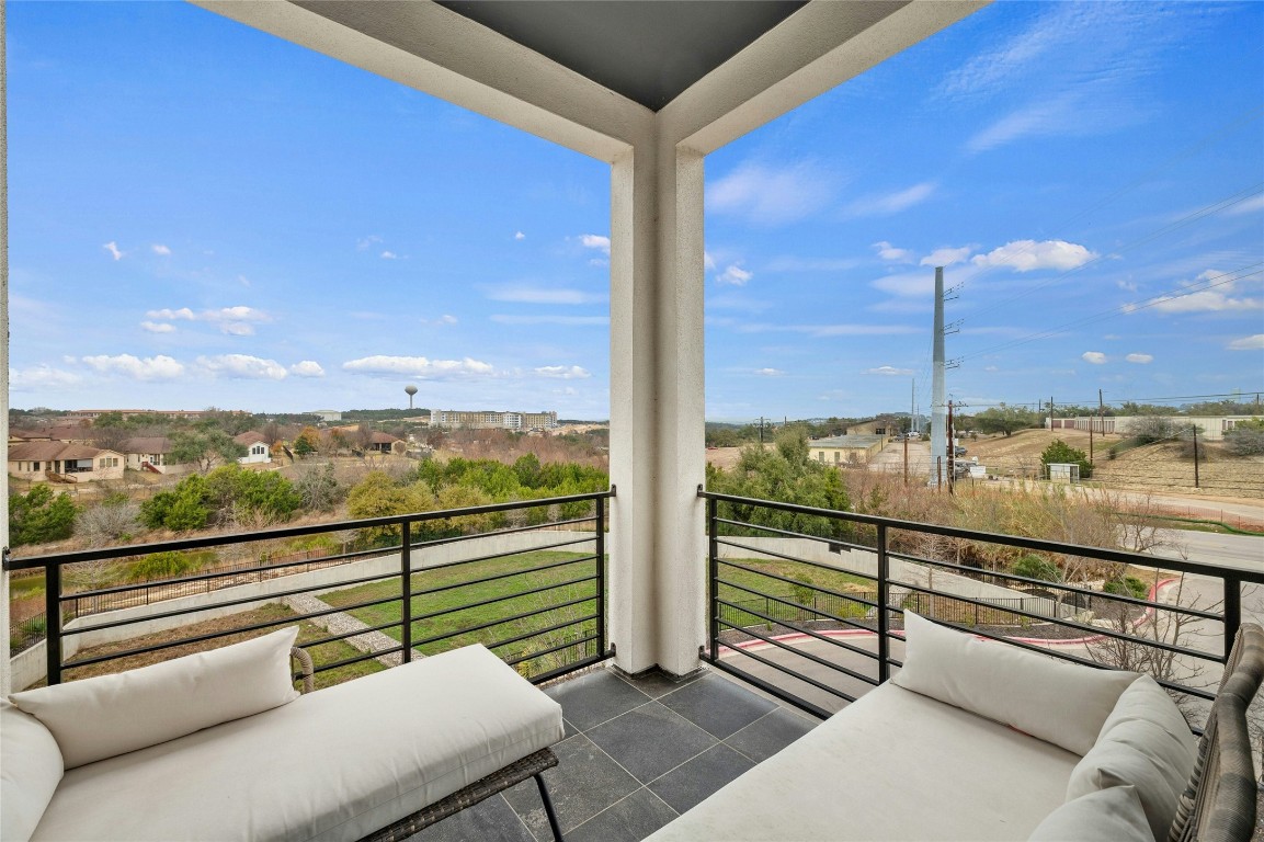 2050 Lohmans Spur Road, Unit 101 Lakeway, TX 78738 - Photo 2 of 31 a view of a balcony with couches and wooden floor