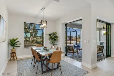 a dining room with furniture potted plants and wooden floor